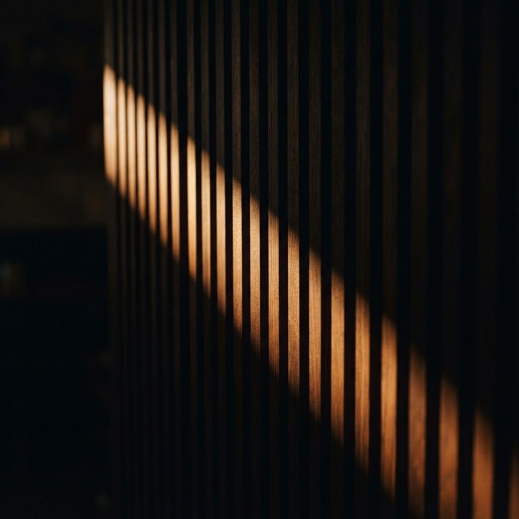 Grazing warm light sweeping across a dark ribbed wood panel